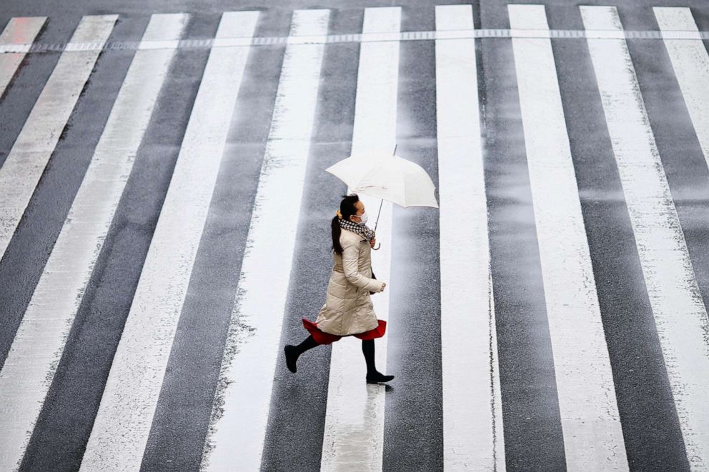 PHOTO: A woman wearing a protective face mask, following an outbreak of the coronavirus disease runs on a street near Tamachi station in Tokyo, March 8, 2020. 