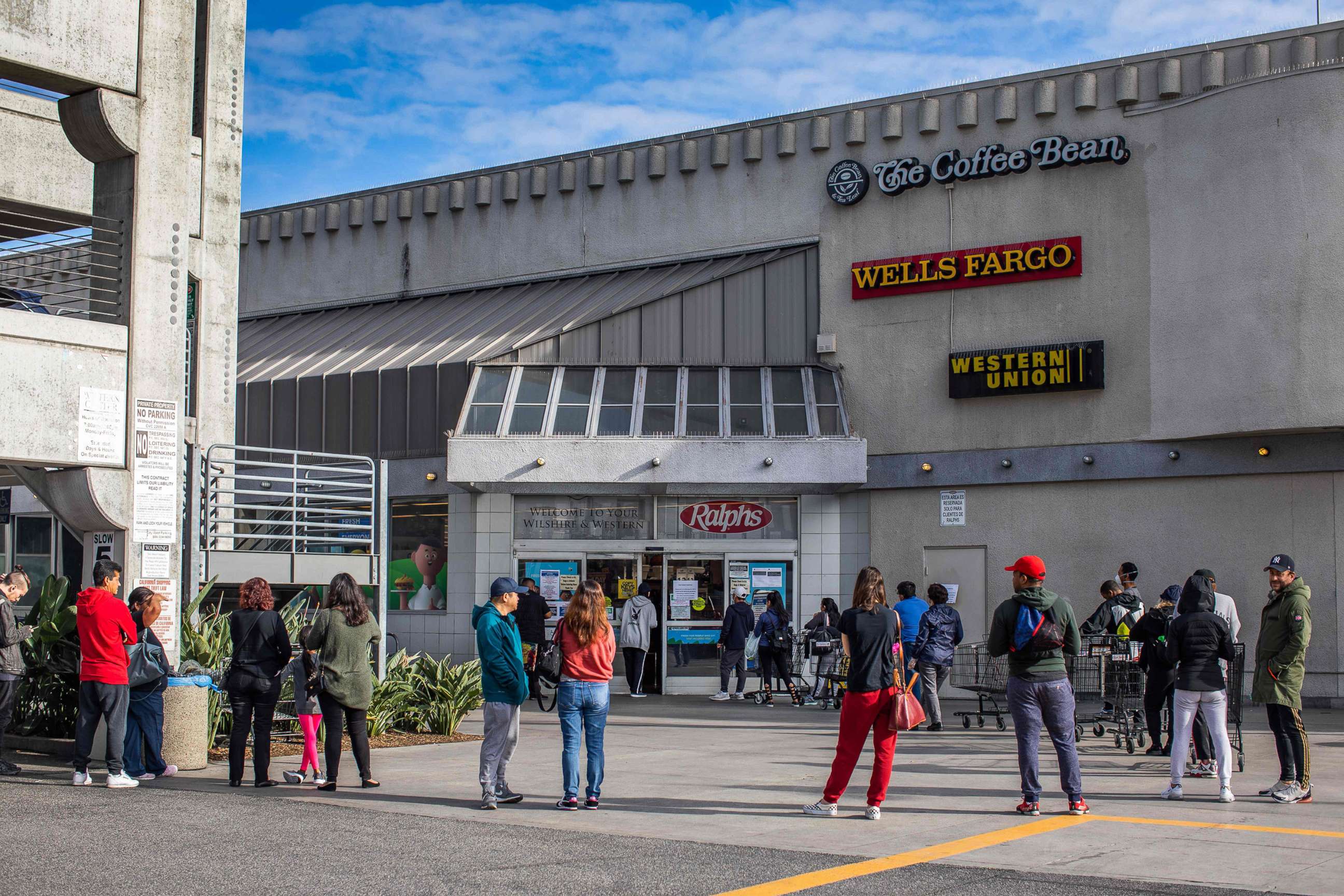 PHOTO: People wait in line to buy food at a grocery store in Los Angeles, March 21, 2020.