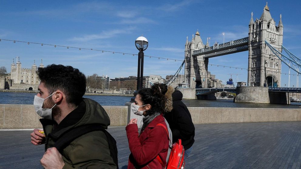 PHOTO: People wearing masks in front of Tower Bridge as the spread of the coronavirus continues, in London, March 23, 2020. 
