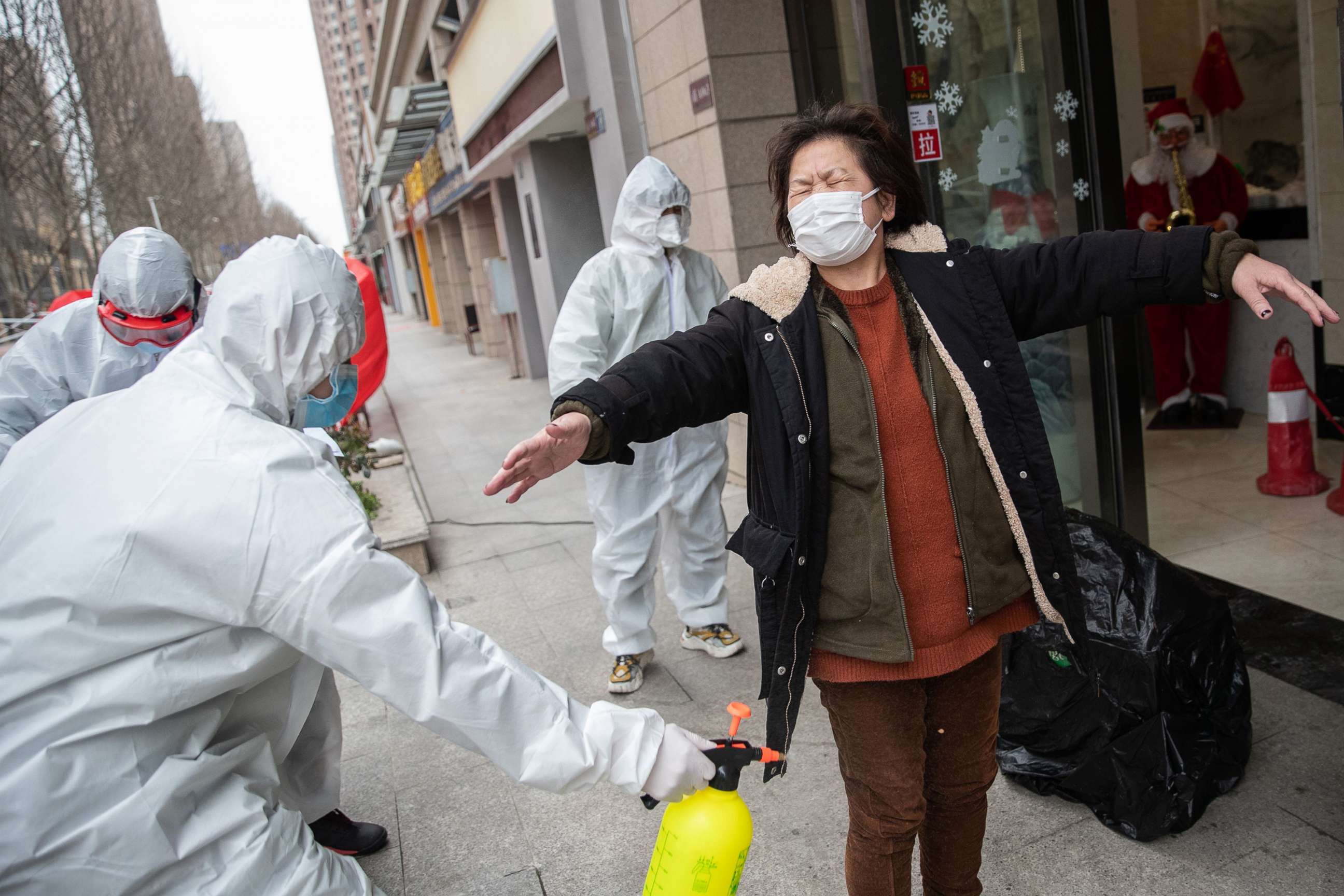 PHOTO: A woman who has recovered from the coronavirus is disinfected by volunteers as she arrives at a hotel for a 14-day quarantine after being discharged from a hospital in Wuhan, in China, March 1, 2020.