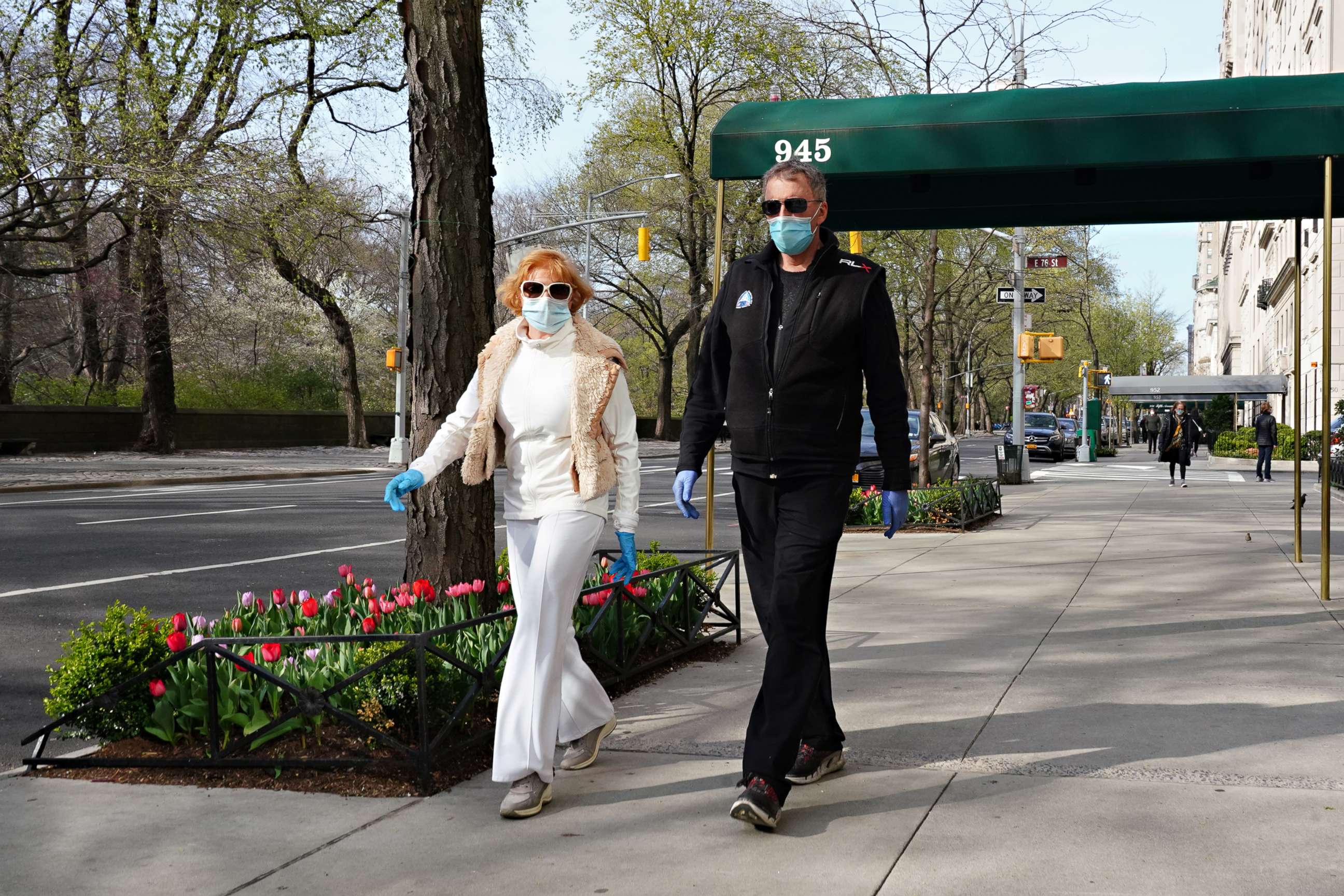 PHOTO: Two people walk on Fifth Avenue wearing protective masks during the coronavirus pandemic, April 12, 2020, in New York.
