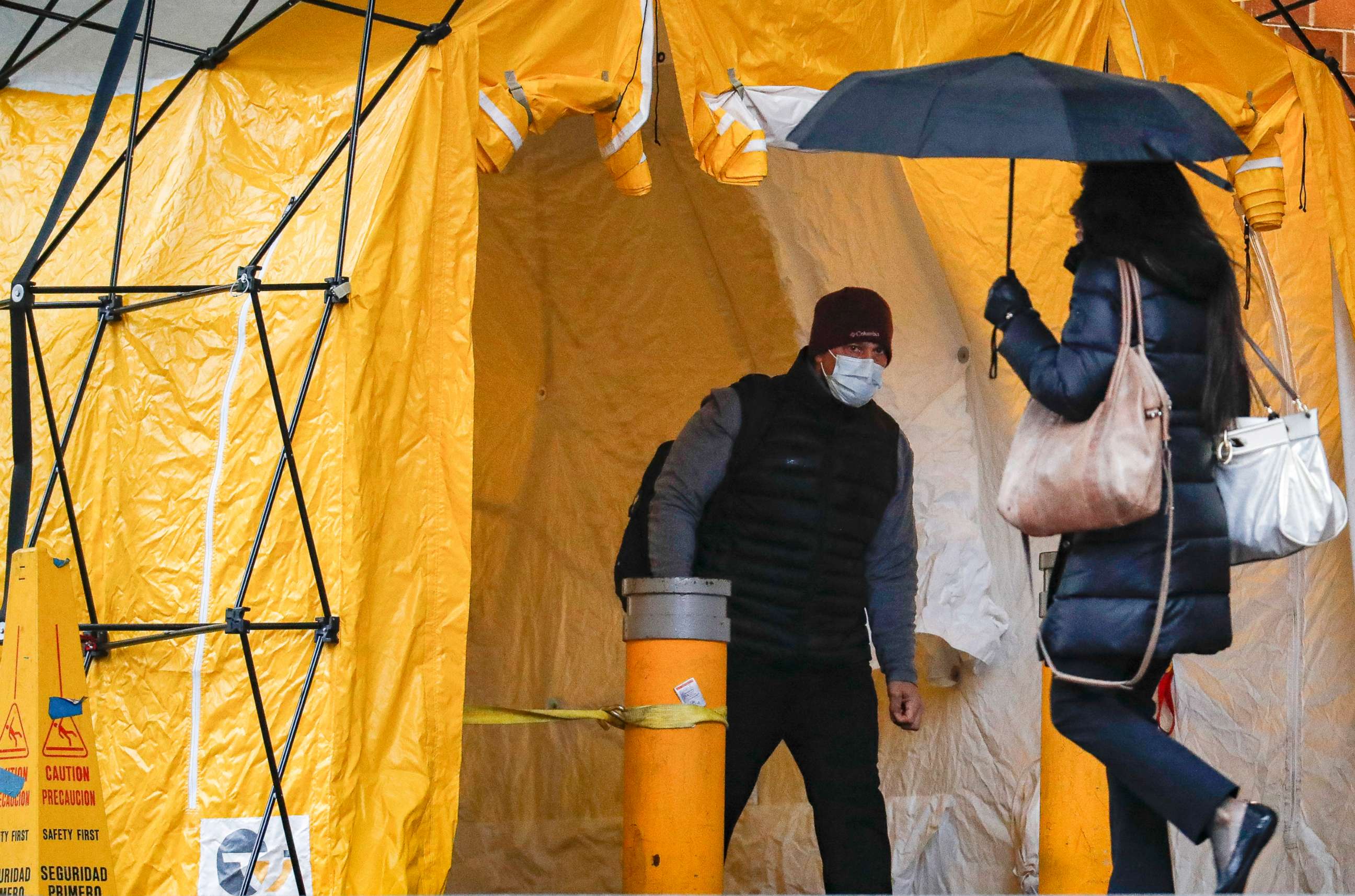 PHOTO: A visitor wearing a face mask waits to be tested for the coronavirus, at the main entrance to the Department of Veterans Affairs Medical Center, March 23, 2020, in New York. 