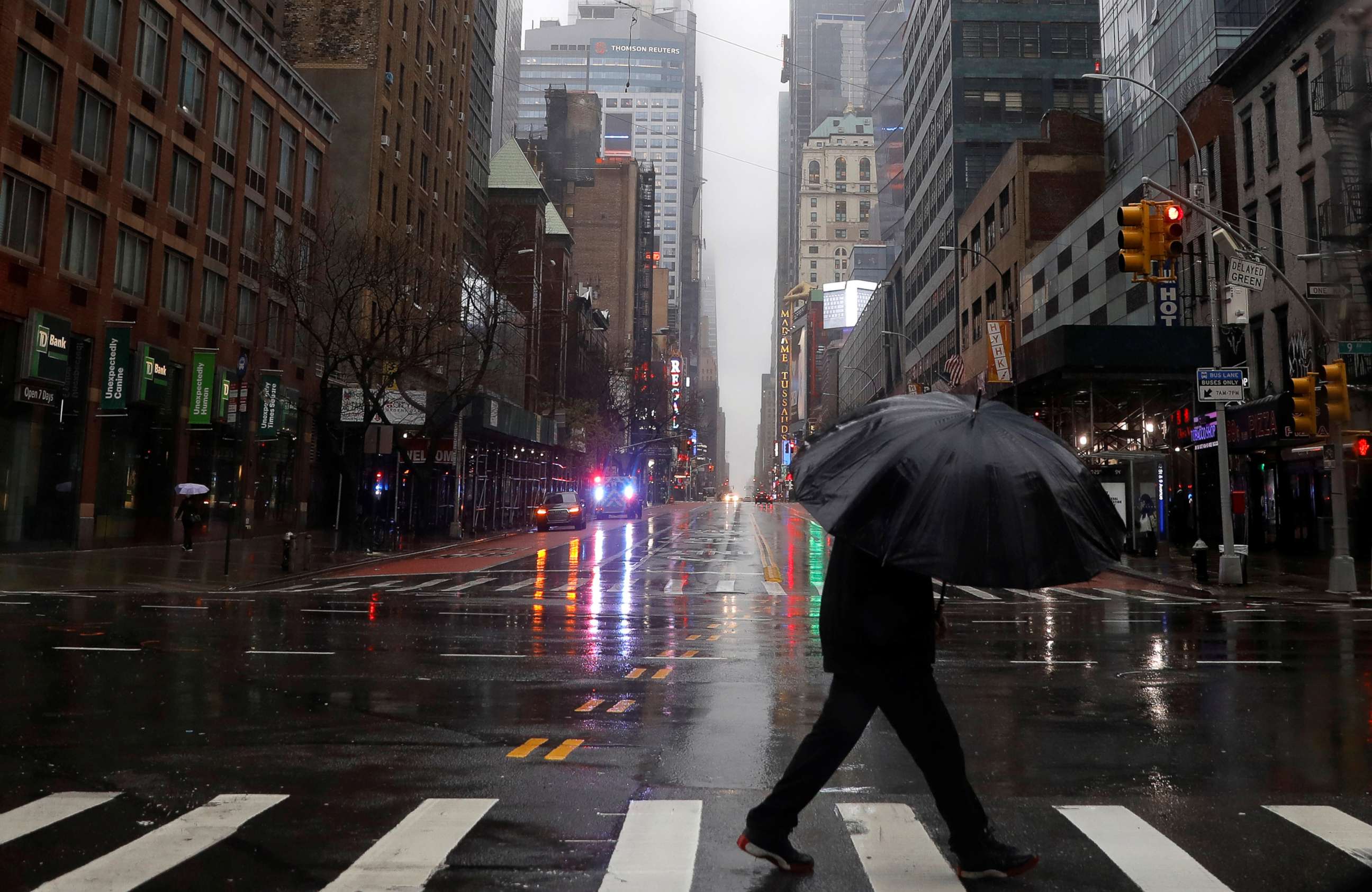 PHOTO: A man walks in heavy rain and high winds across a nearly empty West 42nd street in Manhattan during the outbreak of the coronavirus disease (COVID-19) in New York, April 13, 2020. 