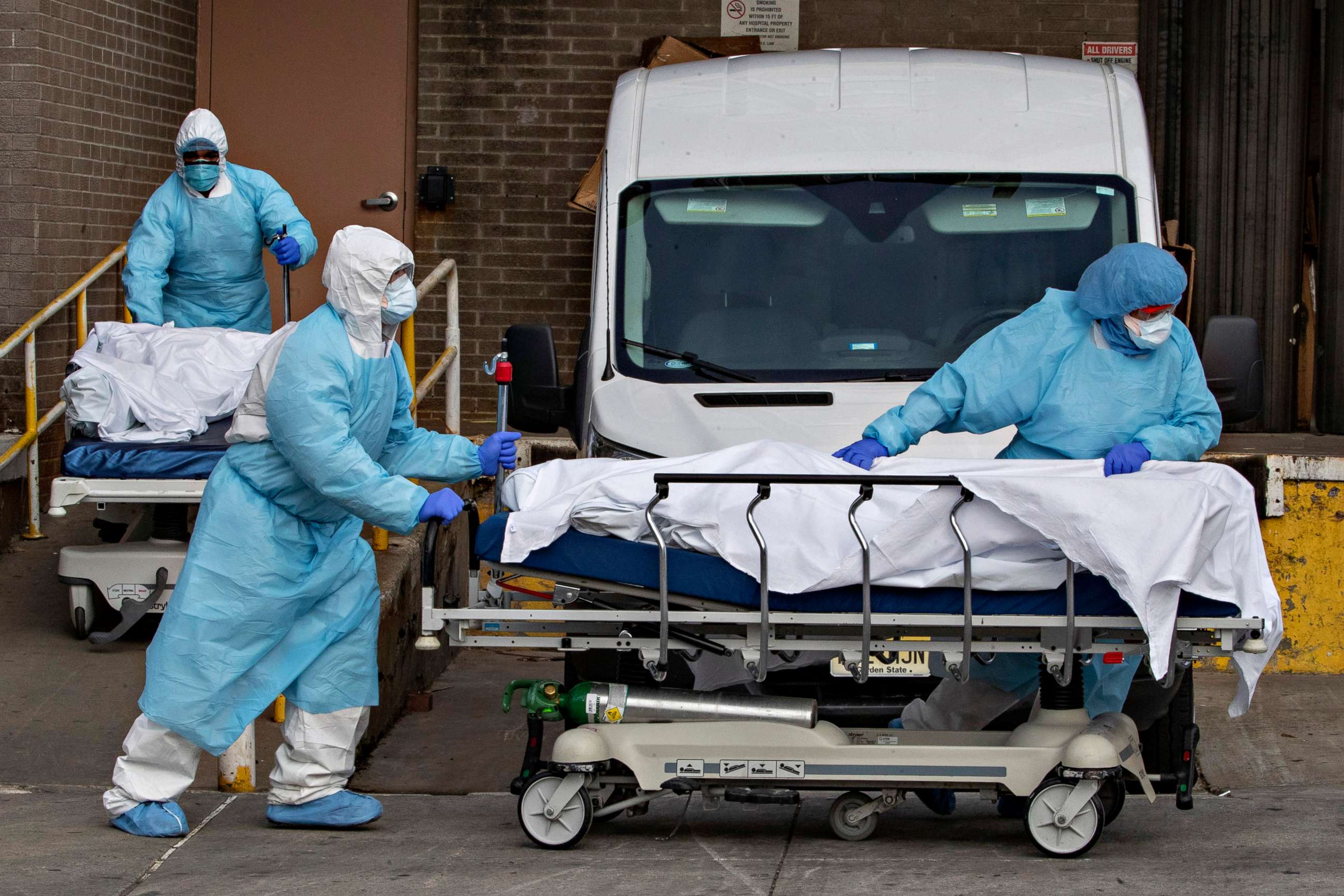 PHOTO: Medical personnel wearing personal protective equipment remove bodies from the Wyckoff Heights Medical Center, April 2, 2020, in the Brooklyn borough of New York City.