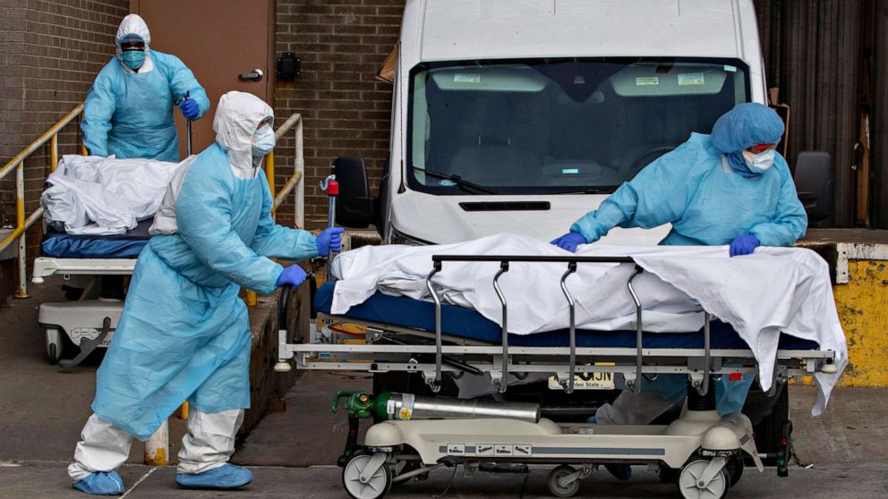 PHOTO: Medical personnel wearing personal protective equipment remove bodies from the Wyckoff Heights Medical Center, April 2, 2020, in the Brooklyn borough of New York City.