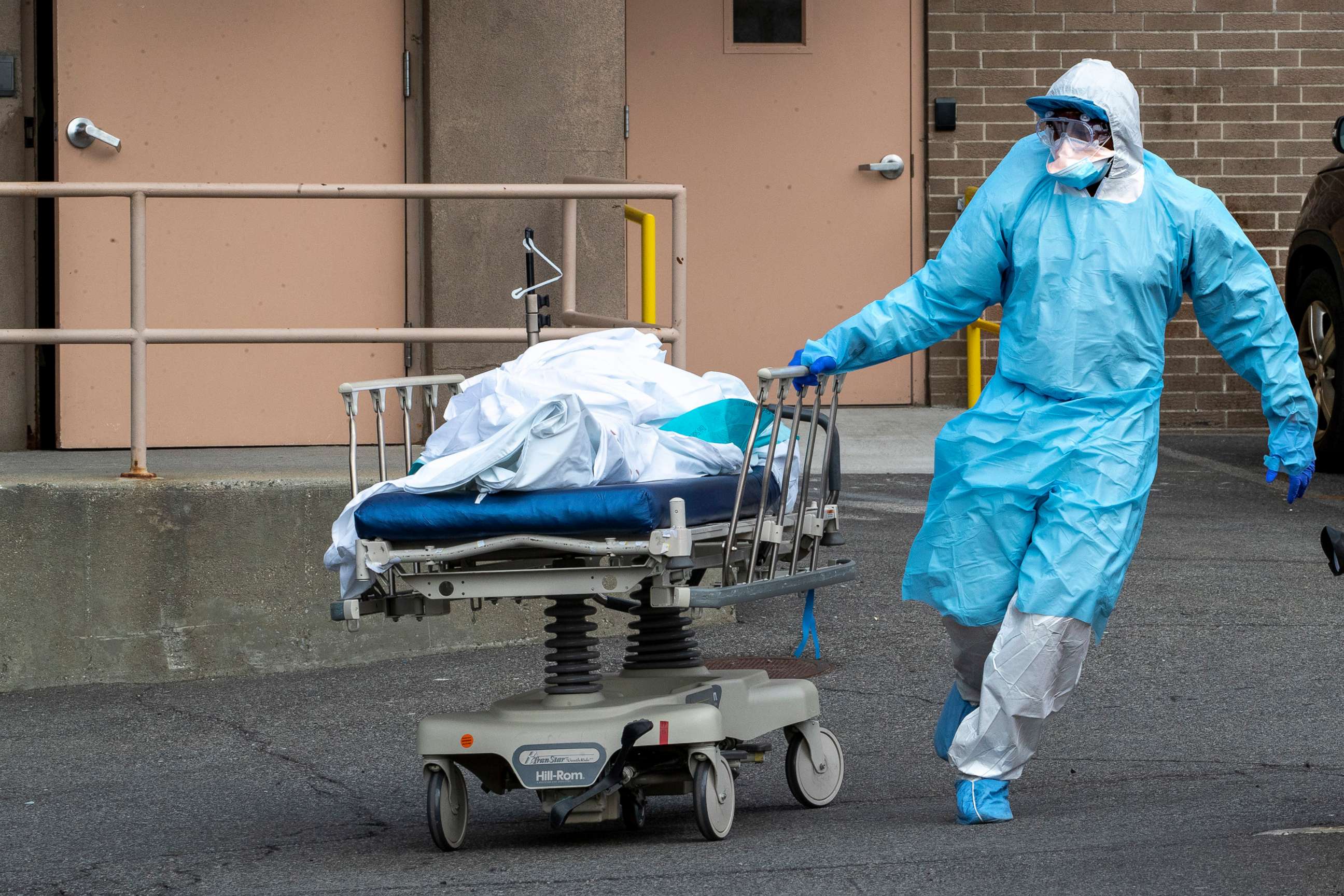 PHOTO: Medical personnel wearing personal protective equipment moves a body from the 
Wyckoff Heights Medical Center to refrigerated containers parked outside, April 2, 2020, in Brooklyn, New York.