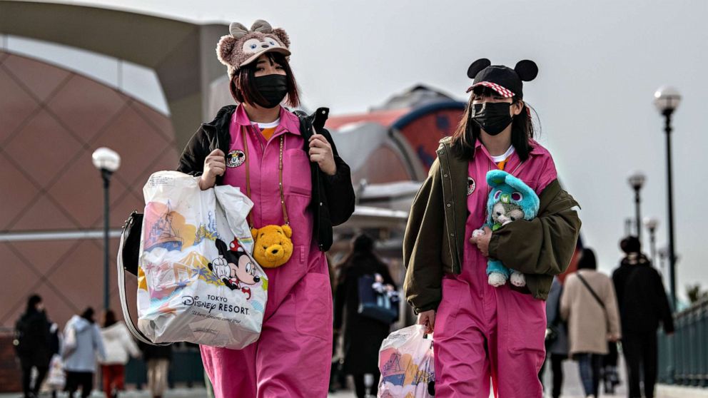 PHOTO: Two women leave Tokyo Disneyland on the day it announced it will close until March 15th because of concerns over the COVID-19 virus, on Feb. 28, 2020 in Japan. 