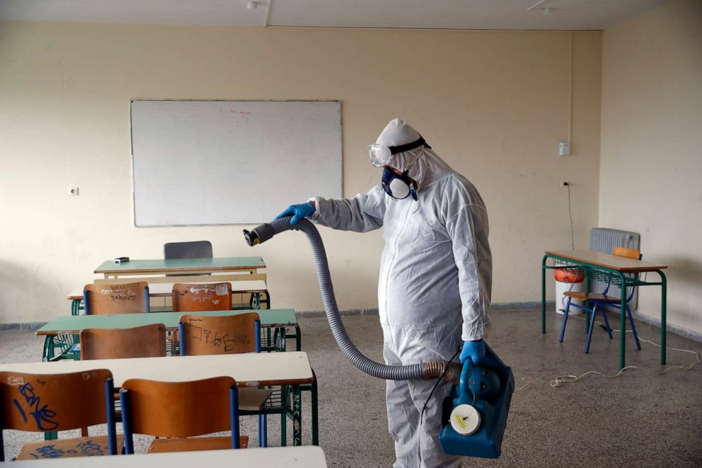 PHOTO: A worker wearing a protective suit sprays disinfectant in a high school in Athens, May 7, 2020.
