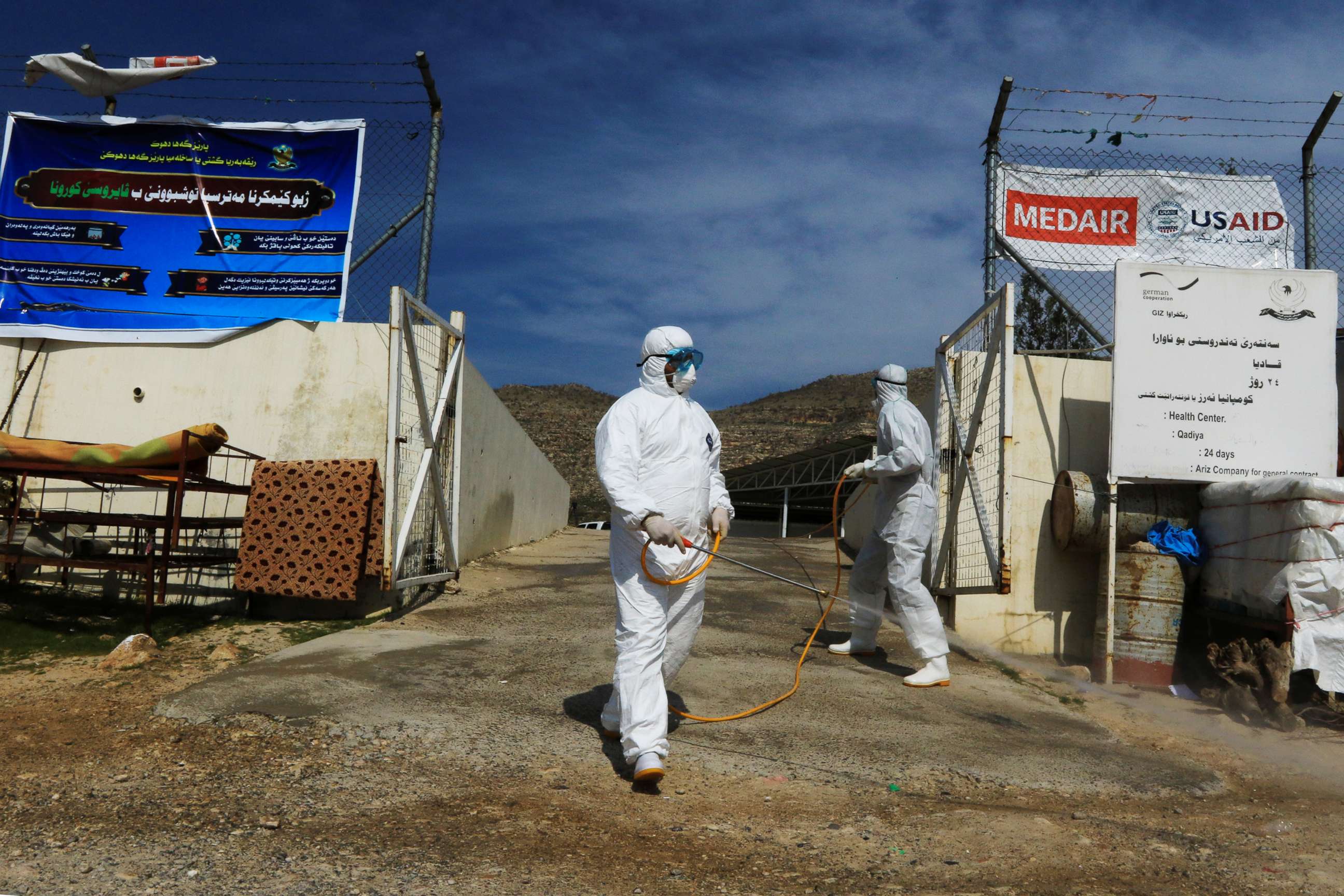 PHOTO: Medical staff spray disinfectant as a preventive measure against the coronavirus inside the Qadia camp for Yazidi sect, on the outskirts of Dohuk province, Iraq, March 11, 2020.