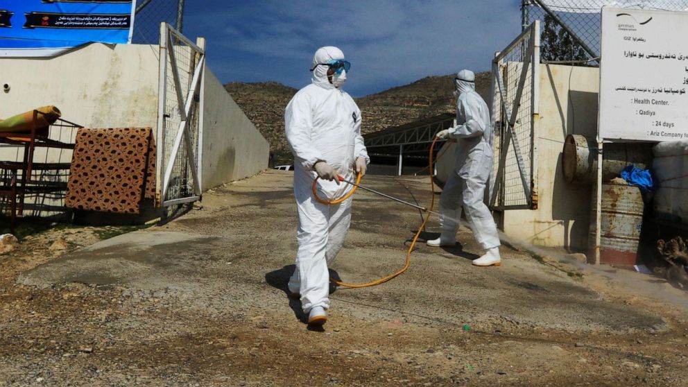 PHOTO: Medical staff spray disinfectant as a preventive measure against the coronavirus inside the Qadia camp for Yazidi sect, on the outskirts of Dohuk province, Iraq, March 11, 2020.