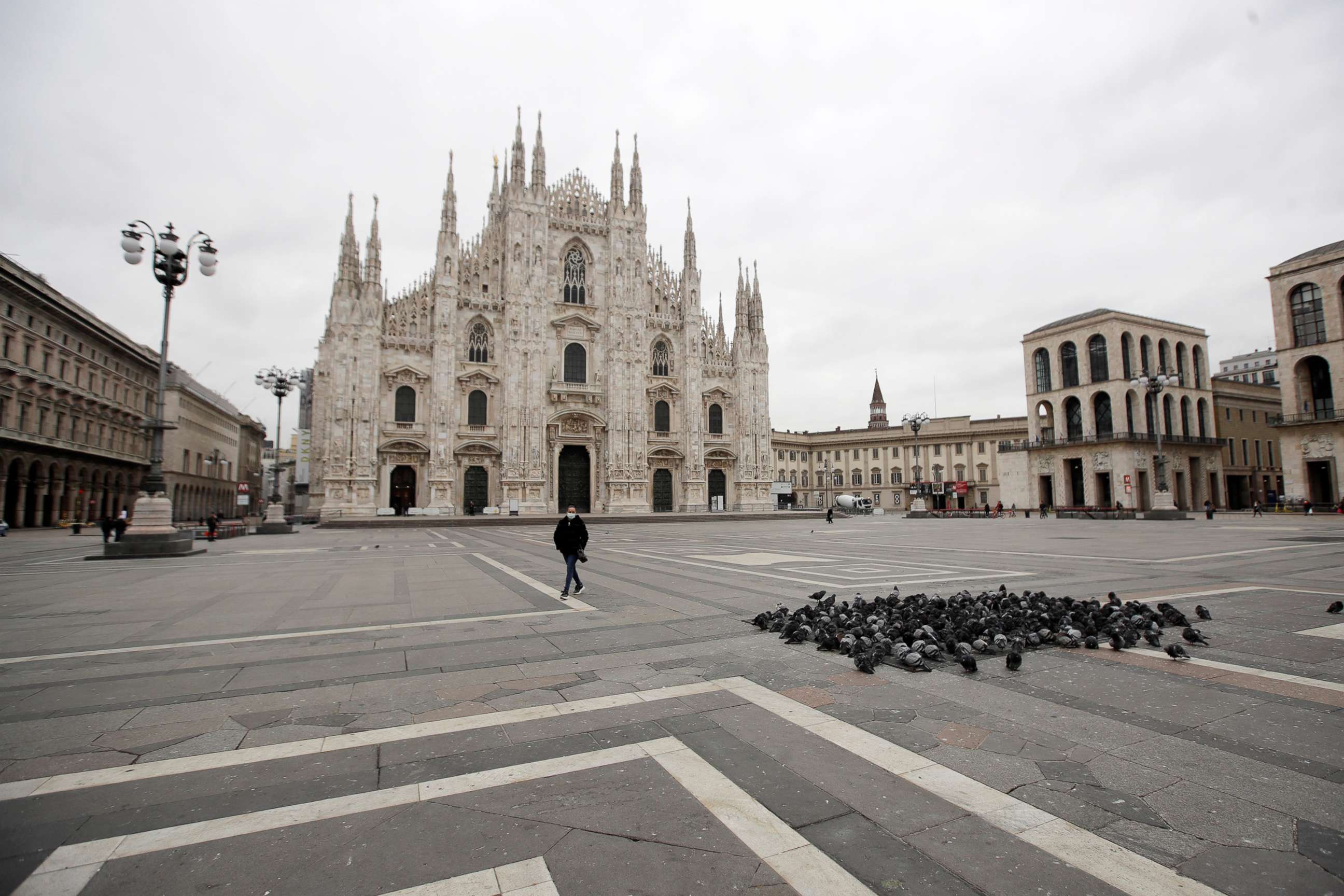 PHOTO: A woman crosses a nearly empty Duomo square in downtown Milan, March 12, 2020. 