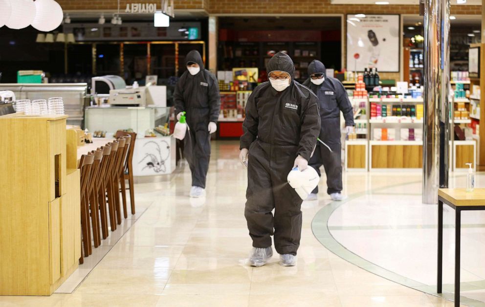 PHOTO: Workers wearing protective suits spray disinfectant as a precaution against the coronavirus at a department store in Daegu, South Korea, Feb. 24, 2020.