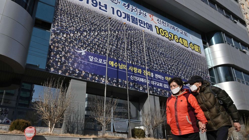 Pedestrians wearing face masks walk in front of the Daegu branch of the Shincheonji Church of Jesus in the southeastern city of Daegu, South Korea, Feb. 24, 2020.Jung Yeon-je/AFP via Getty Images