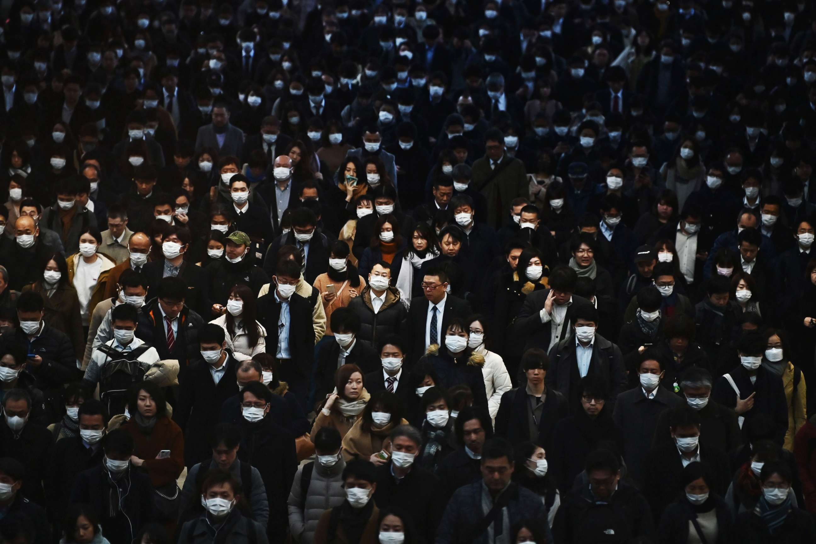 PHOTO: Mask-clad commuters make their way to work during morning rush hour at the Shinagawa train station, in Tokyo on Feb. 28, 2020. \