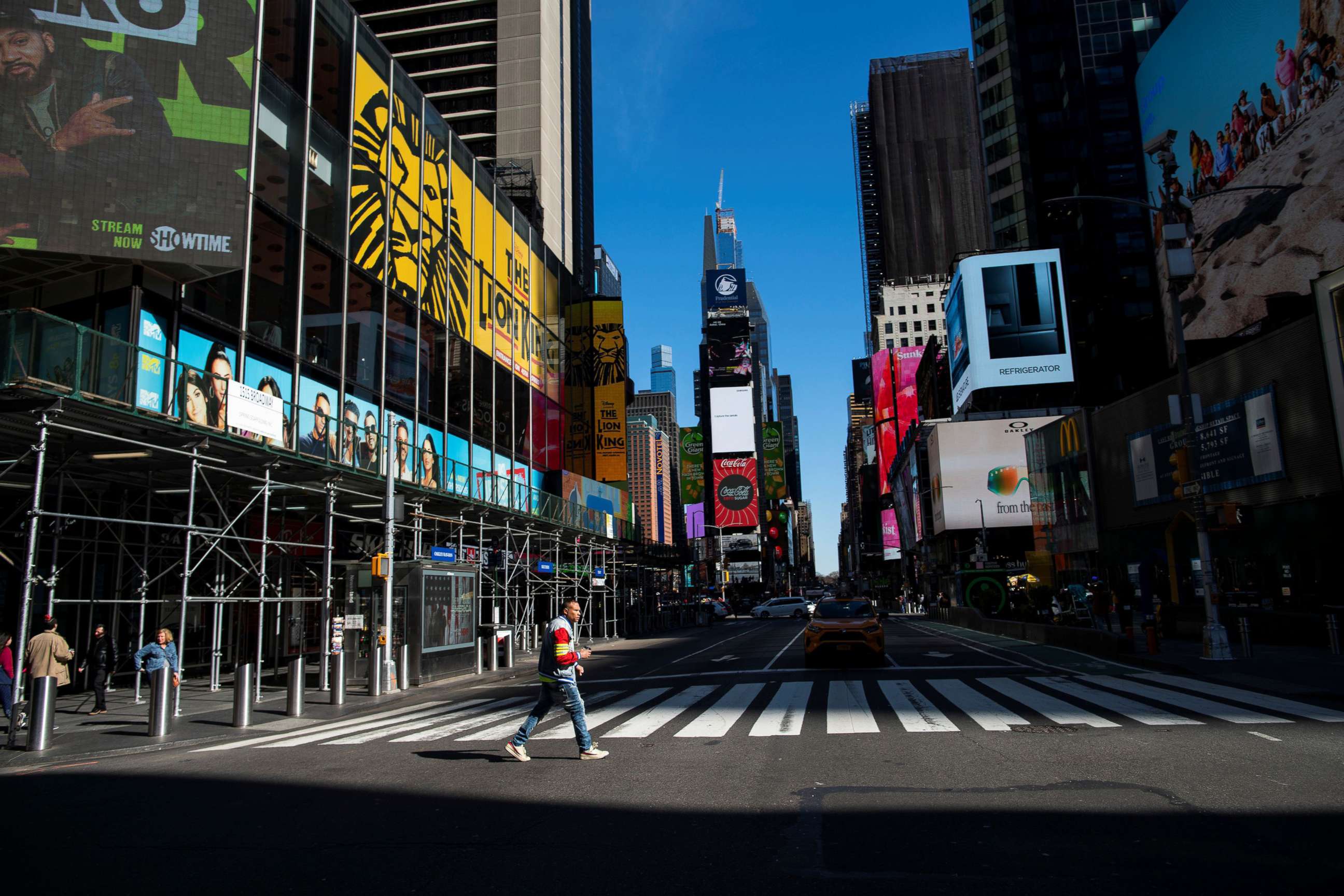 PHOTO: A man crosses a 7 Avenue in a nearly empty Times Square in New York City, March 14, 2020.