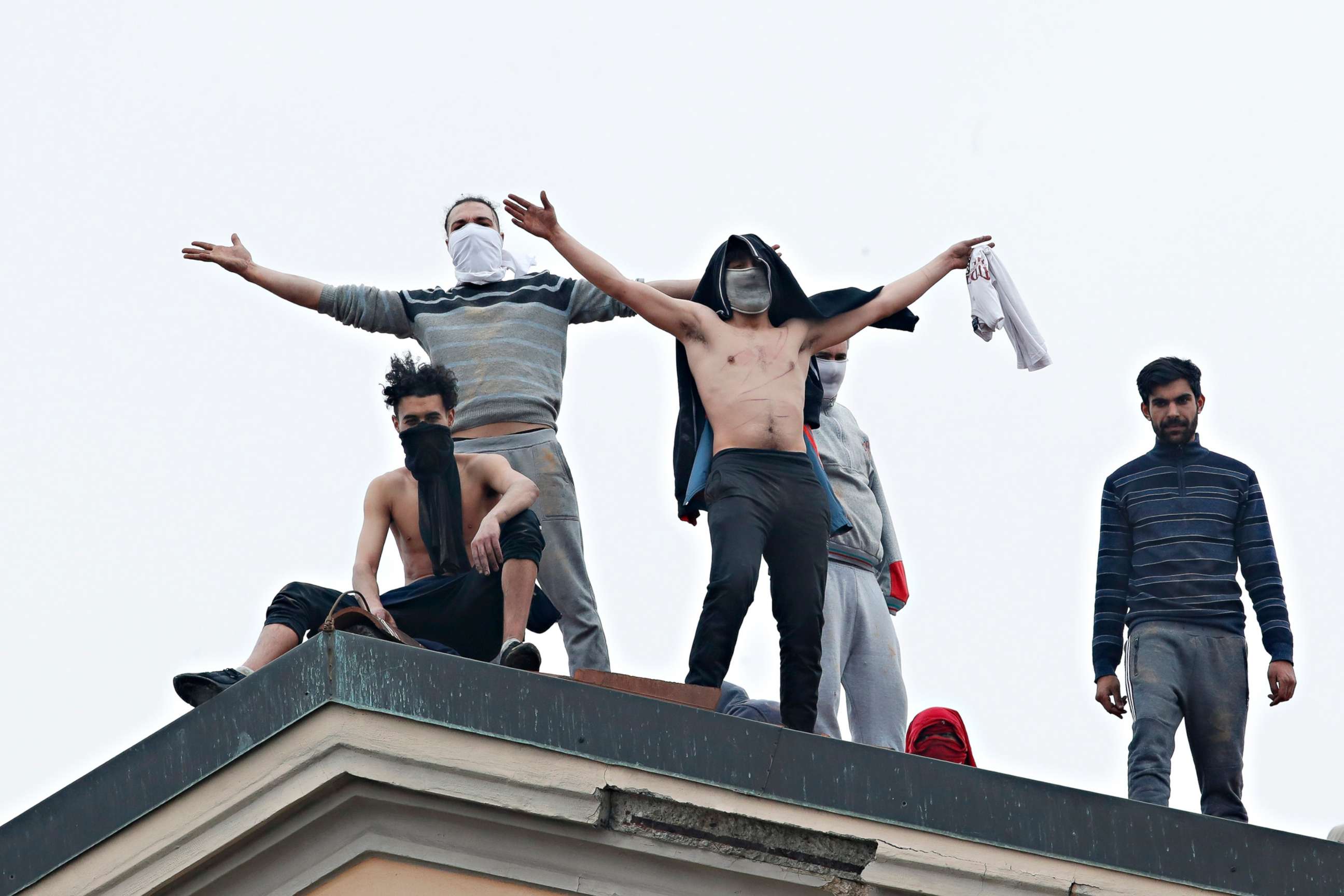 PHOTO: Inmates stand on the roof of the San Vittore prison to protest after restrictions that were imposed on family visits to prevent coronavirus transmissions, in Milan, Italy, March 9, 2020.