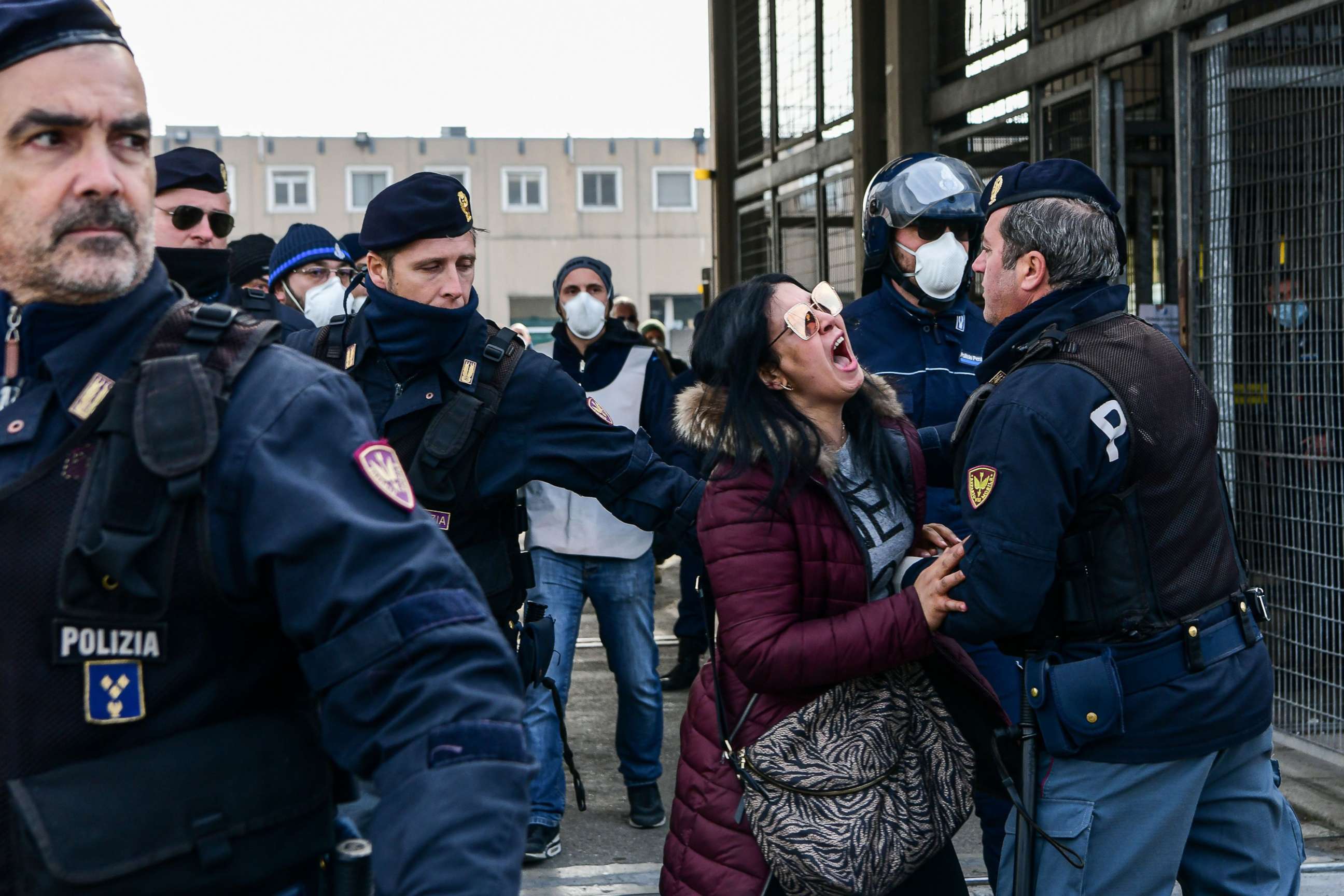 PHOTO: Police officers hold off an inmate's relative shouting in protest outside the SantAnna prison in Modena, Emilia-Romagna, in one of Italy's quarantine red zones on March 9, 2020.