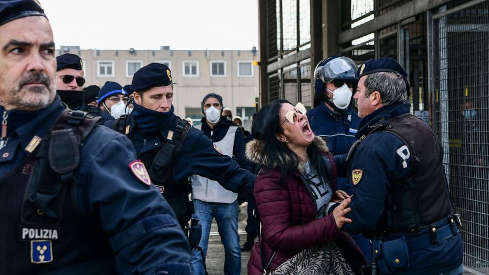PHOTO: Police officers hold off an inmate's relative shouting in protest outside the SantAnna prison in Modena, Emilia-Romagna, in one of Italy's quarantine red zones on March 9, 2020.