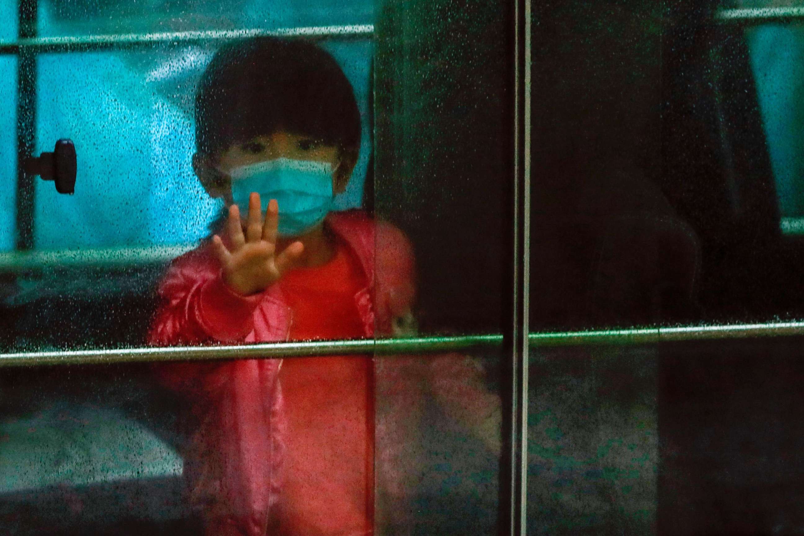 PHOTO: A child waves as she sits in a vehicle carrying residents evacuated from a public housing building, following the outbreak of the novel coronavirus, outside Hong Mei House, at Cheung Hong Estate in Hong Kong, Feb. 11, 2020.