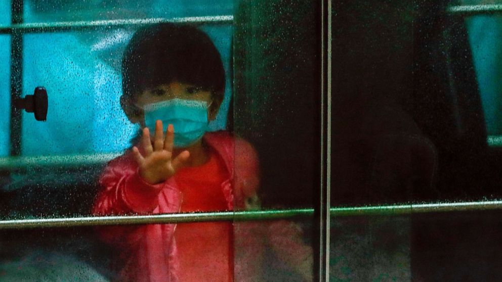 PHOTO: A child waves as she sits in a vehicle carrying residents evacuated from a public housing building, following the outbreak of the novel coronavirus, outside Hong Mei House, at Cheung Hong Estate in Hong Kong, Feb. 11, 2020.