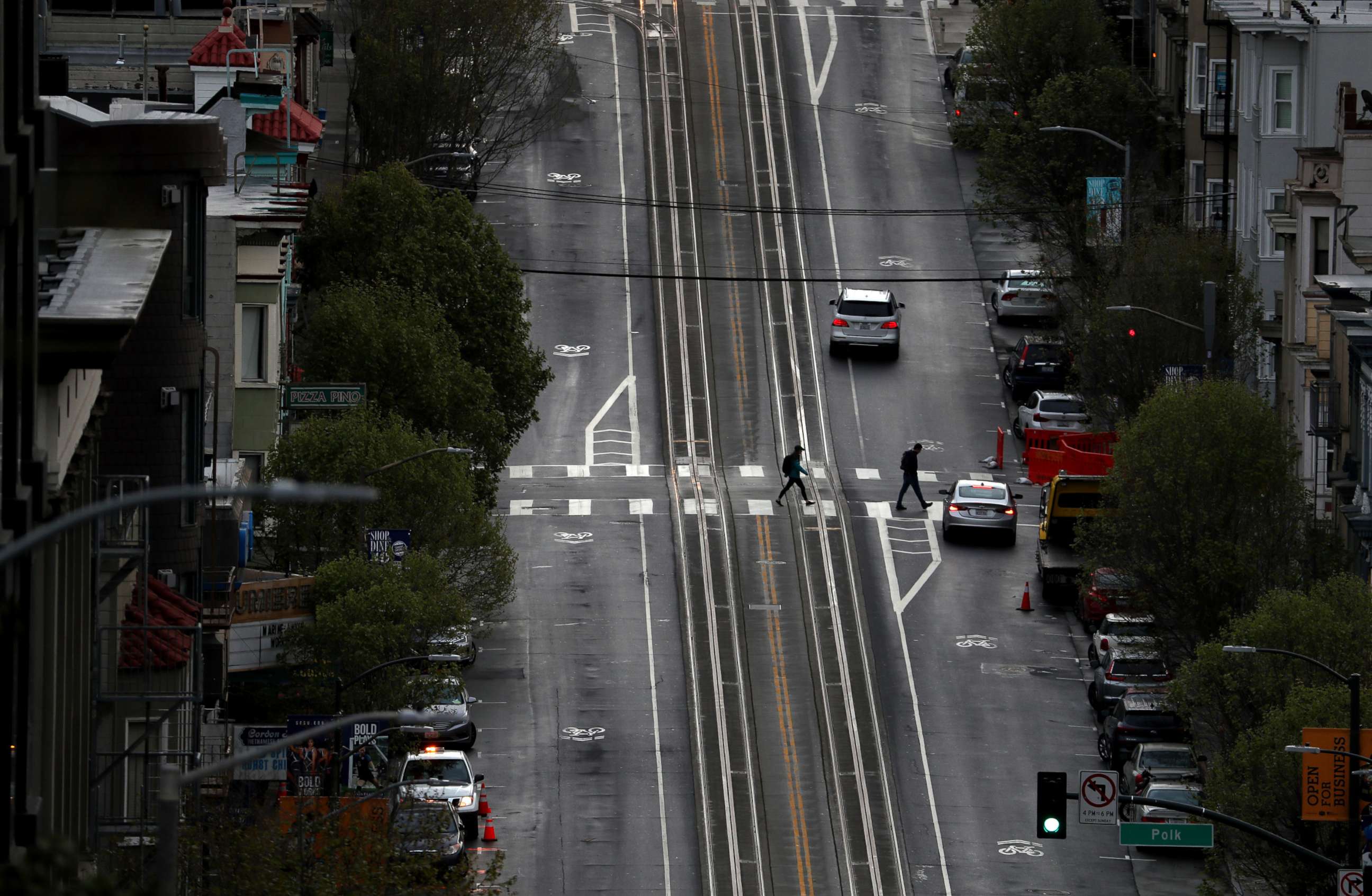 PHOTO: Two pedestrians cross an empty street, on March 16, 2020 in San Francisco.