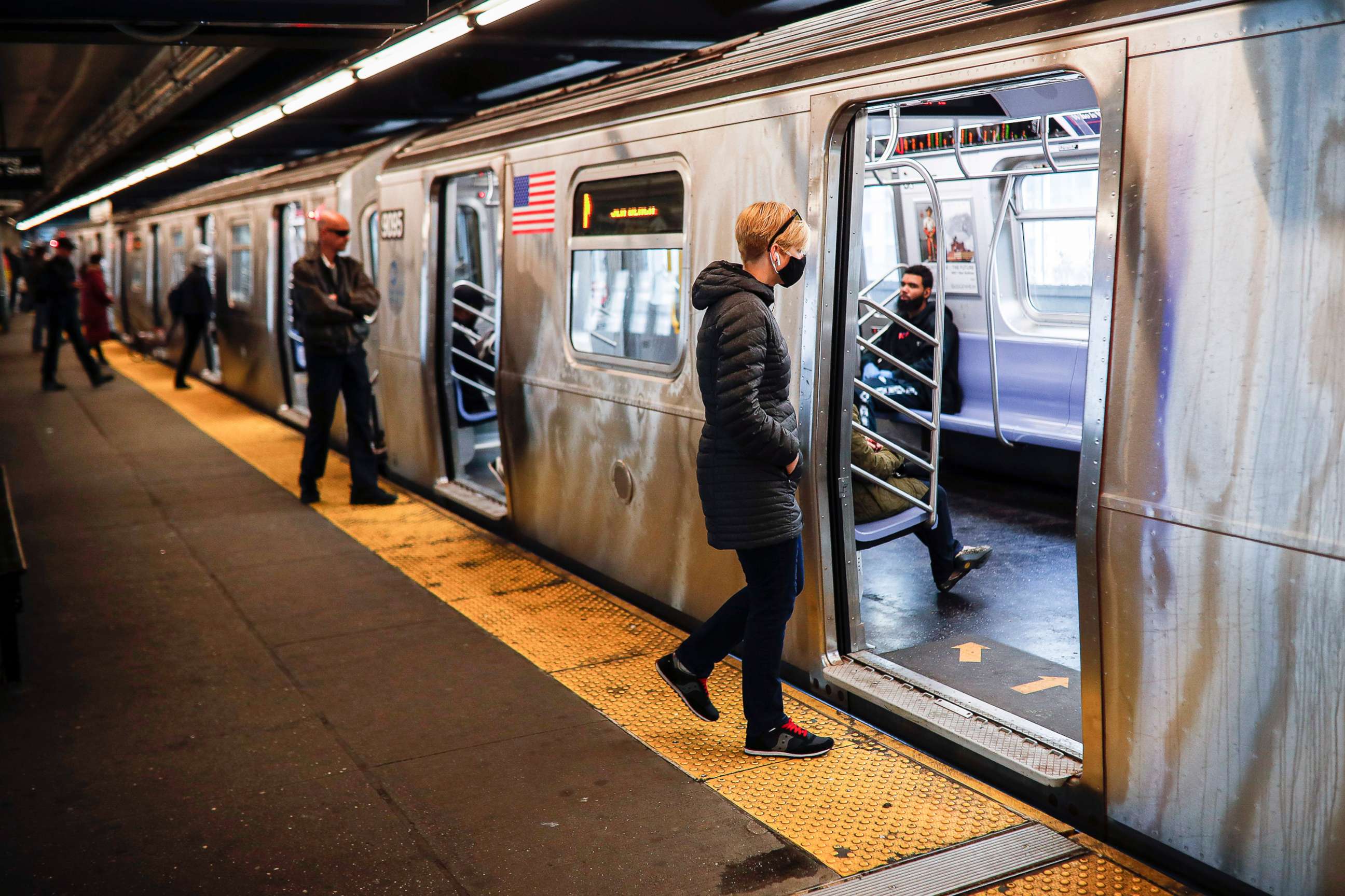 PHOTO: Riders, some wearing masks and gloves as a protective measure over coronavirus concerns, enter a New York City subway train, April 7, 2020, in New York City.