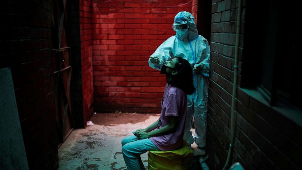 PHOTO: A health worker in personal protective equipment uses a swab to collect a nasal sample from a person at a local health center to test for COVID-19 in New Delhi, India, on Aug. 31, 2020.