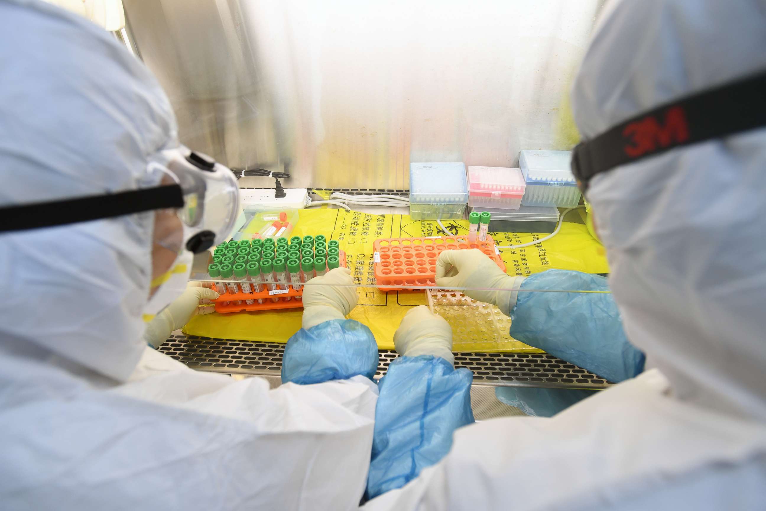 PHOTO: Workers in protective suits examine specimens inside a laboratory following an outbreak of the novel coronavirus in Wuhan, Hubei province, China February 6, 2020. 