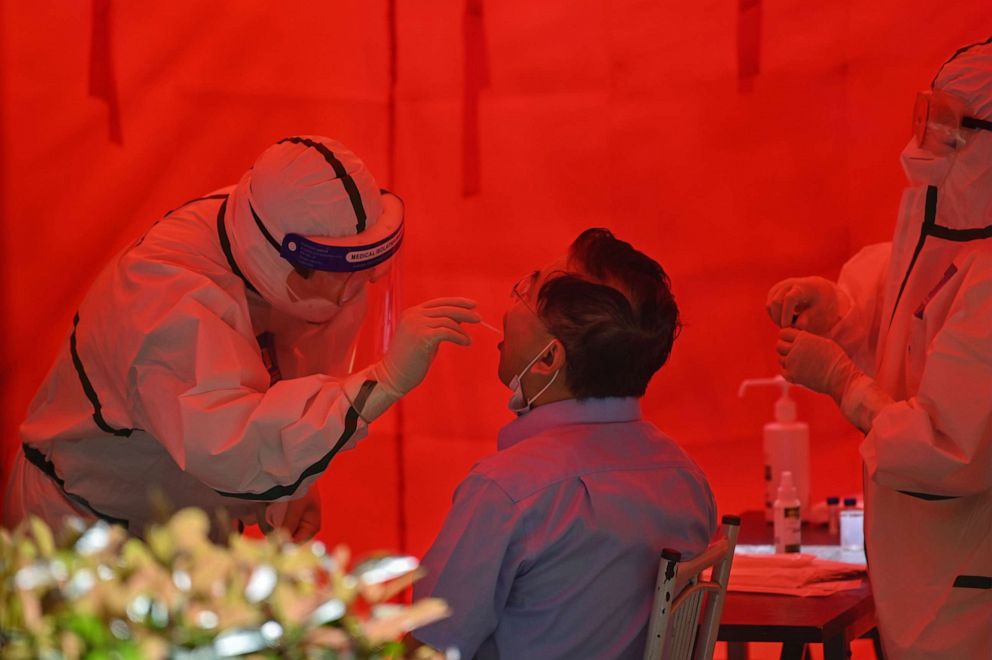 PHOTO: A medical worker takes a swab sample from a man to test for COVID-19 in Wuhan in China's central Hubei province on May 19, 2020.