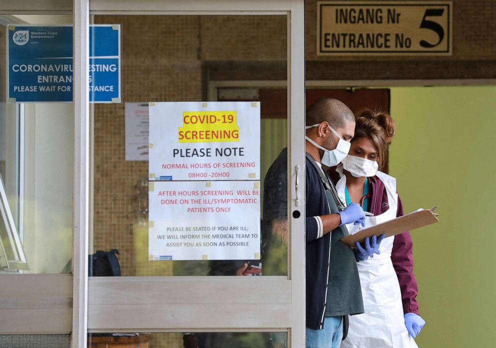 PHOTO: Medical workers check a file at a testing center at Tygerberg Hospital in Cape Town, South Africa, on April 6, 2020, as the country continued its 21-day nationwide lockdown in an effort to control the spread of the novel coronavirus.