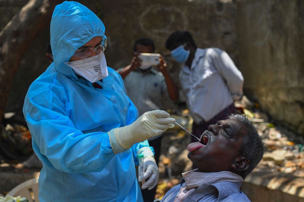 PHOTO: A doctor takes a swab sample during a COVID-19 testing drive inside the Dharavi slums amid a government-imposed nationwide lockdown as a preventive measure against the spread of the novel coronavirus, in Mumbai, India, on April 16, 2020.