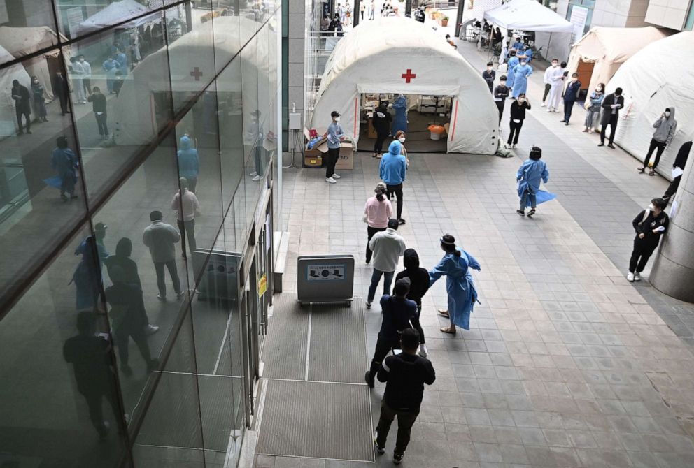 PHOTO: People wait in line to be tested for COVID-19  at a testing station in the nightlife district of Itaewon in Seoul, South Korea, on May 12, 2020.