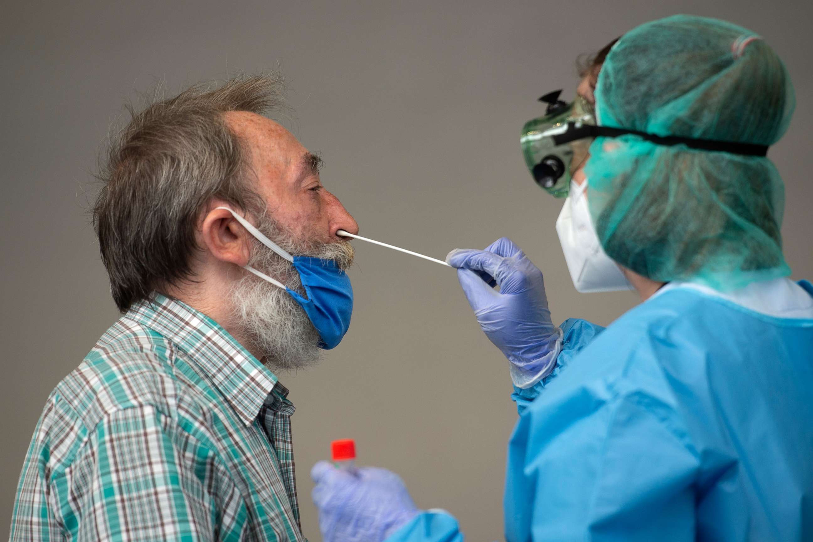 PHOTO: A healthcare worker uses a swab to collect a sample from a man at a temporary testing centre for the novel coronavirus in Spanish Basque city of Azpeitia on August 15, 2020 following a new outbreak in the city.