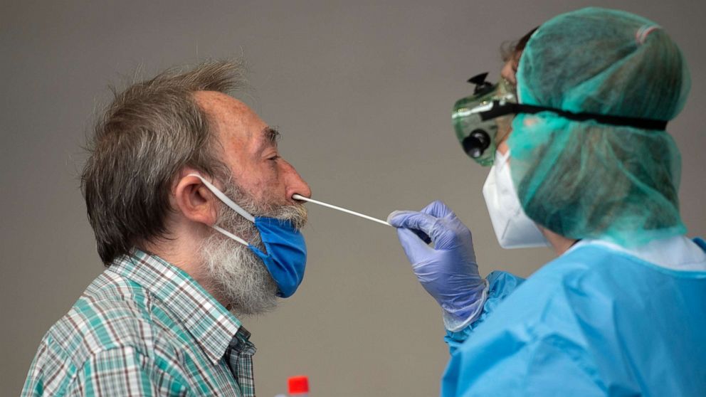 PHOTO: A healthcare worker uses a swab to collect a sample from a man at a temporary testing centre for the novel coronavirus in Spanish Basque city of Azpeitia on August 15, 2020 following a new outbreak in the city.