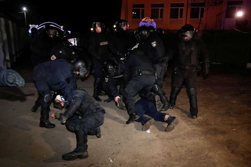 PHOTO: Ukrainian law enforcement officers detain a man during a protest against the arrival of a plane carrying evacuees from coronavirus-hit China's Hubei province in the village of Novi Sanzhary in Poltava region, Ukraine, Feb. 20, 2020.