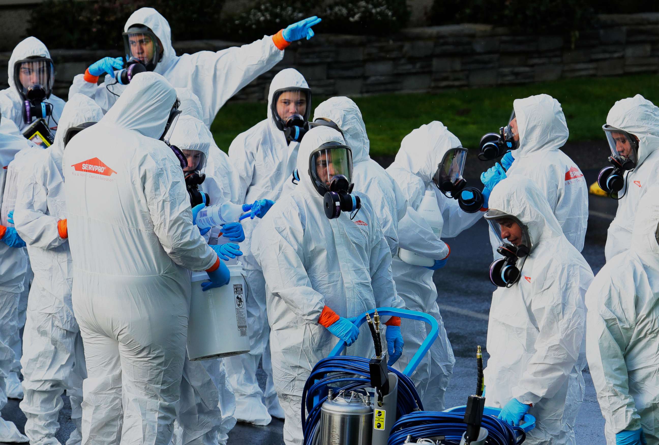 PHOTO: Workers from a Servpro disaster recovery team wearing protective suits and respirators enter the Life Care Center in Kirkland, Wash., to begin cleaning and disinfecting the facility, March 11, 2020, near Seattle.