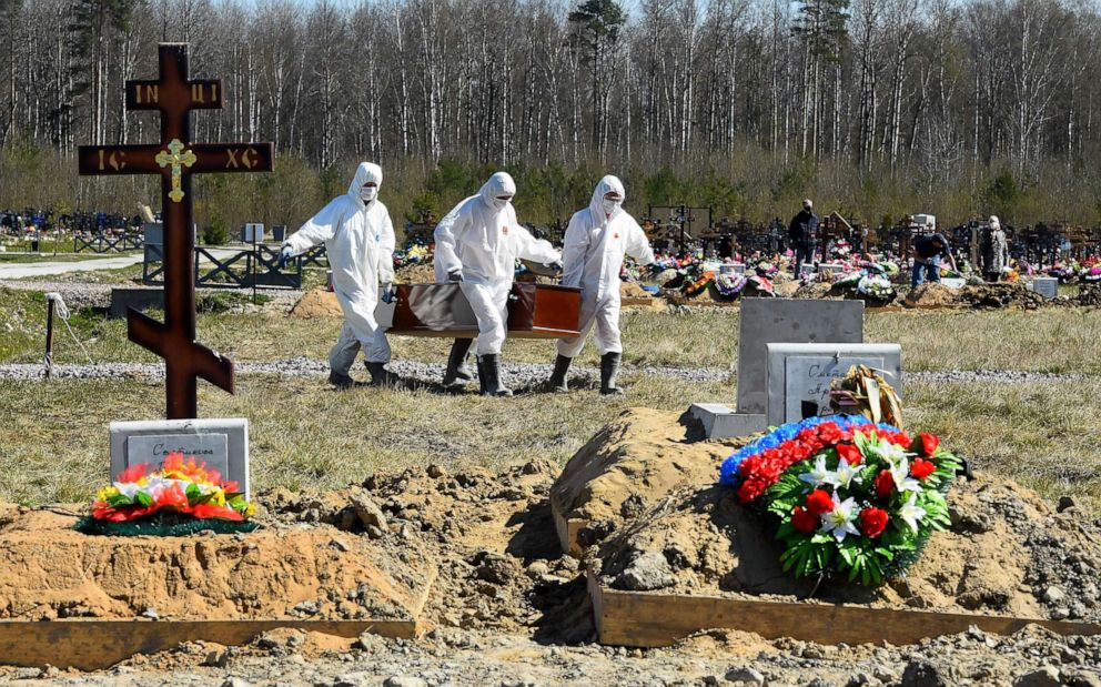 PHOTO: Cemetery workers wearing protective gear bury a COVID-19 victim at a cemetery on the outskirts of Saint Petersburg, Russia, on May 6, 2020.