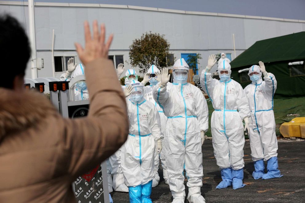 PHOTO: Medical personnel in protective suits wave hands to a patient who is discharged from the Leishenshan Hospital after recovering from the novel coronavirus, in Wuhan, China, March 1, 2020.