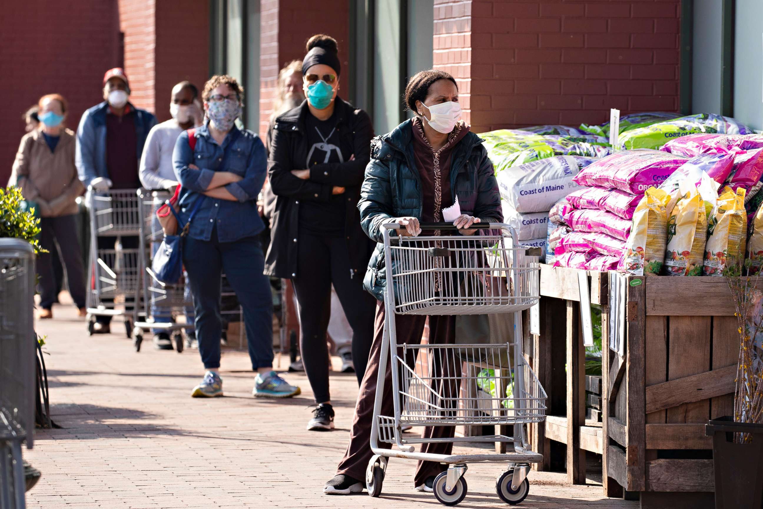 PHOTO: Customers practice social distance guidelines while waiting in a line to enter a Whole Foods Market store in Silver Spring, Md., April 7, 2020.
