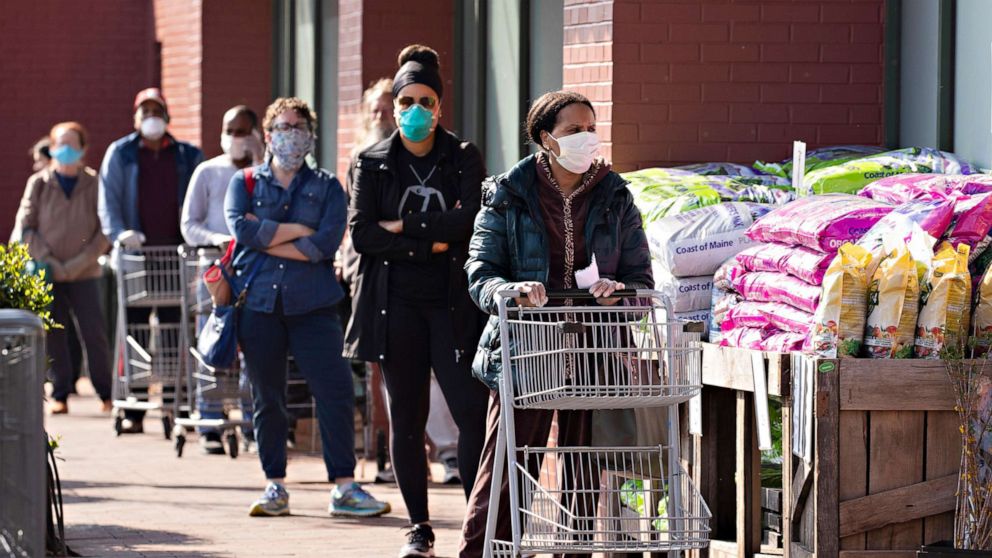 PHOTO: Customers practice social distance guidelines while waiting in a line to enter a Whole Foods Market store in Silver Spring, Md., April 7, 2020.