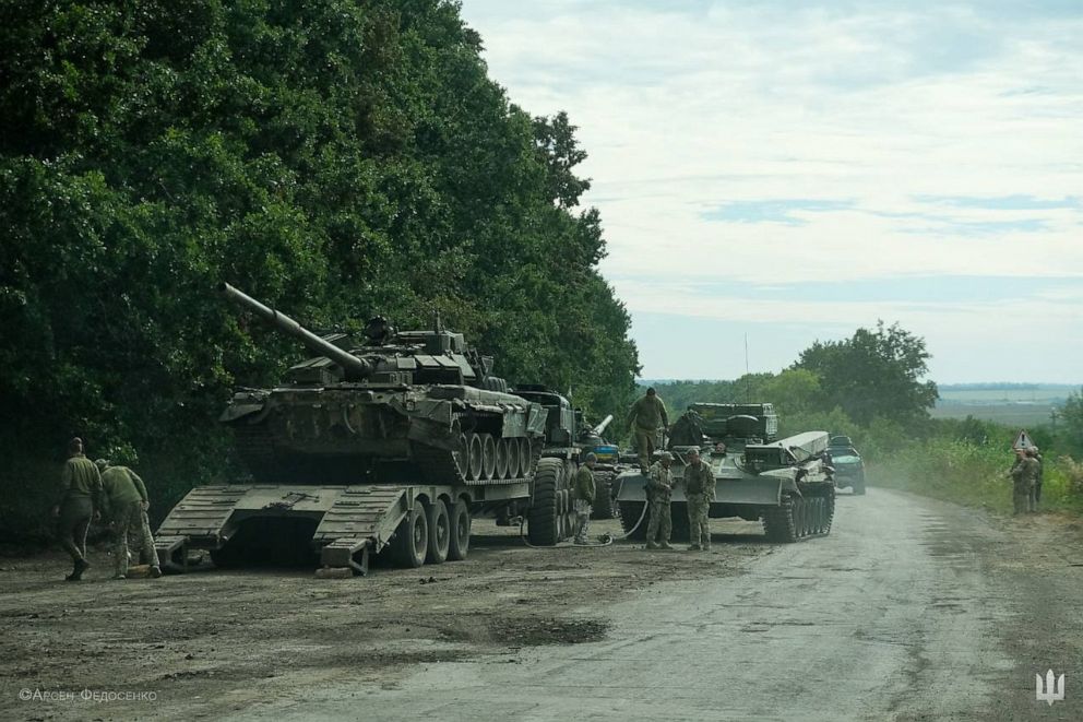 PHOTO: This handout photograph taken on Sept. 9, 2022 and released by the press-service of the Commander-in-Chief of the Ukrainian Armed Forces on Sept. 11, 2022, shows Ukrainian soldiers loading an abandoned Russian military vehicle on a trailer.