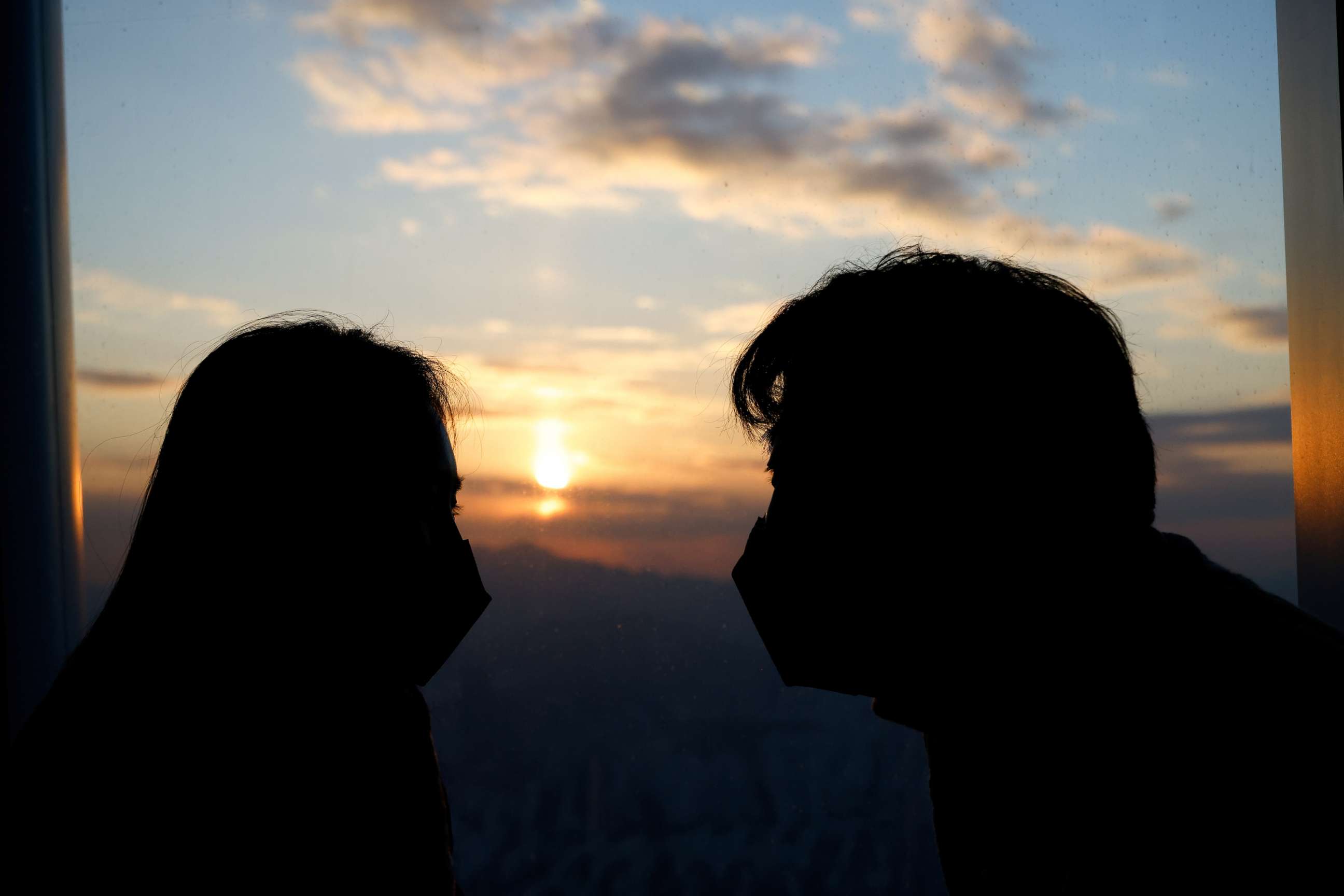 PHOTO: A couple looks at the setting sun from the Seoul Sky Observatory in Seoul, South Korea, on Dec. 31, 2020.