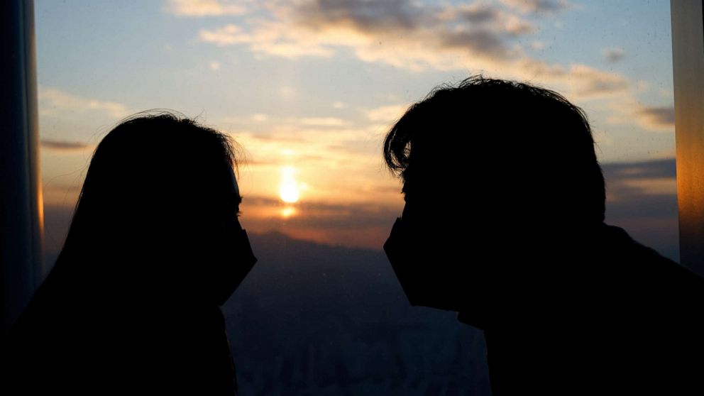PHOTO: A couple looks at the setting sun from the Seoul Sky Observatory in Seoul, South Korea, on Dec. 31, 2020.