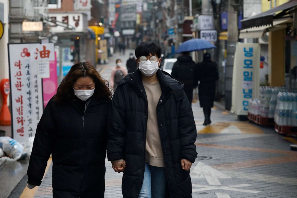 PHOTO: A couple wearing face masks walks on a street in Seoul, South Korea, on Dec. 13, 2020.