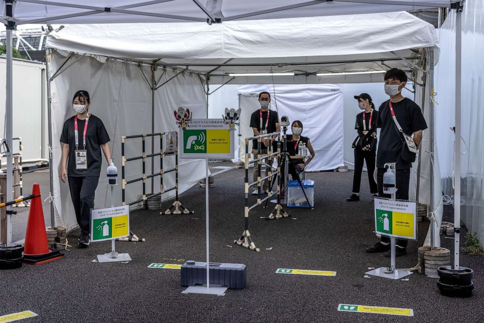 PHOTO: Staff operate coronavirus health screening at an entrance to Tokyo Stadium, the Olympic venue for football, rugby and modern pentathlon, on July 25, 2021 in Tokyo, Japan.