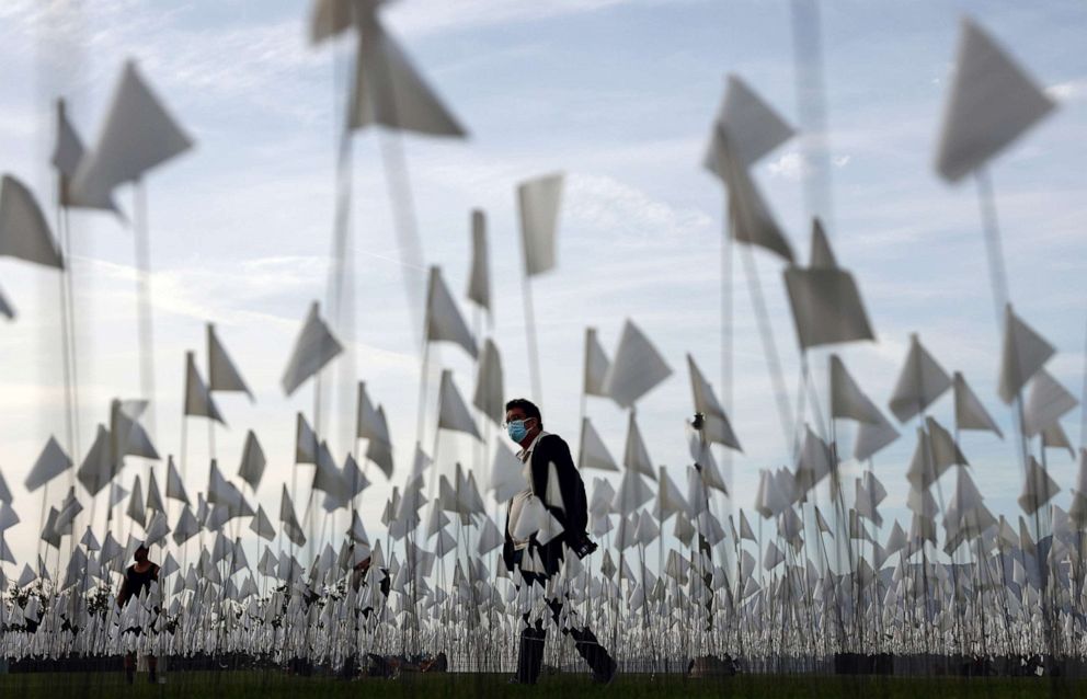 PHOTO: A person walks past a white flag memorial installation outside Griffith Observatory honoring the nearly 27,000 Los Angeles County residents who have died from COVID-19 since the start of the pandemic, Nov. 18, 2021, in Los Angeles, Calif.