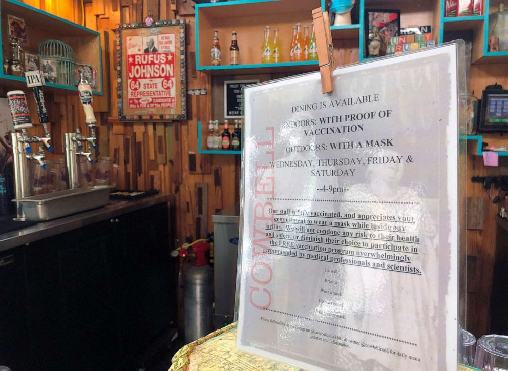 PHOTO: A sign at a counter in Cowbell restaurant on Aug. 6, 2021 in New Orleans, 2021, informs customers that they can eat indoors if they have proof of vaccination against COVID-19.