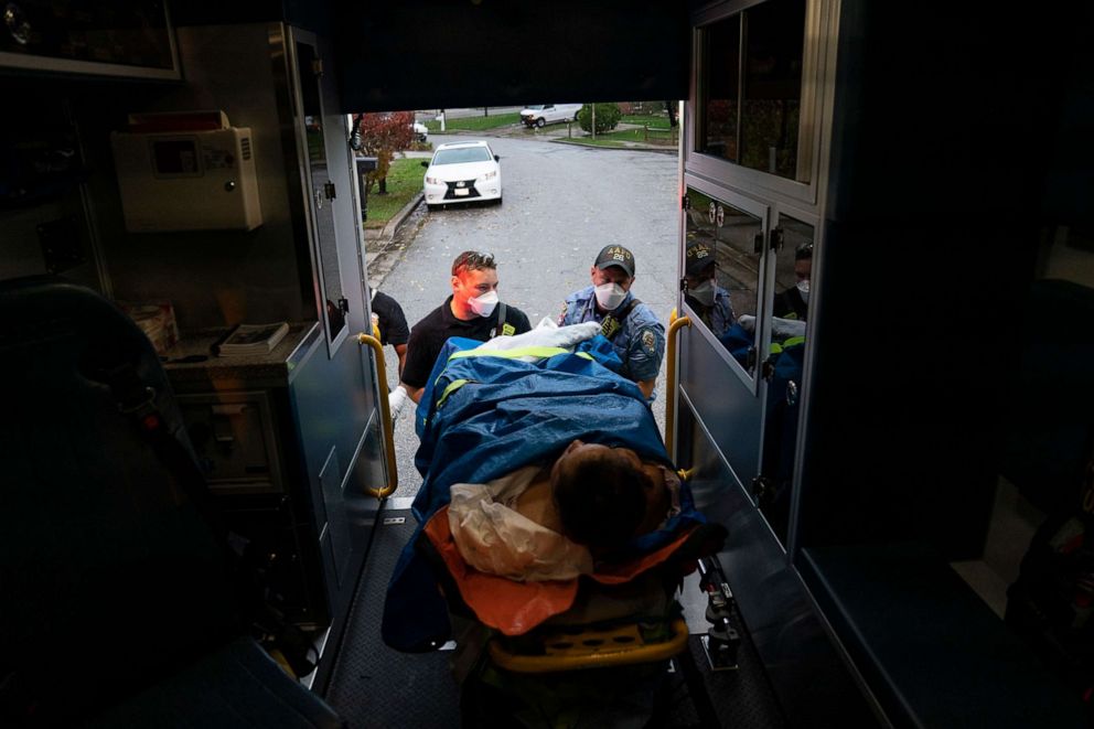 PHOTO: Firefighters and paramedics with Anne Arundel County Fire Department load a patient into an ambulance while responding to a 911 emergency call on Nov. 11, 2020 in Glen Burnie, Md.