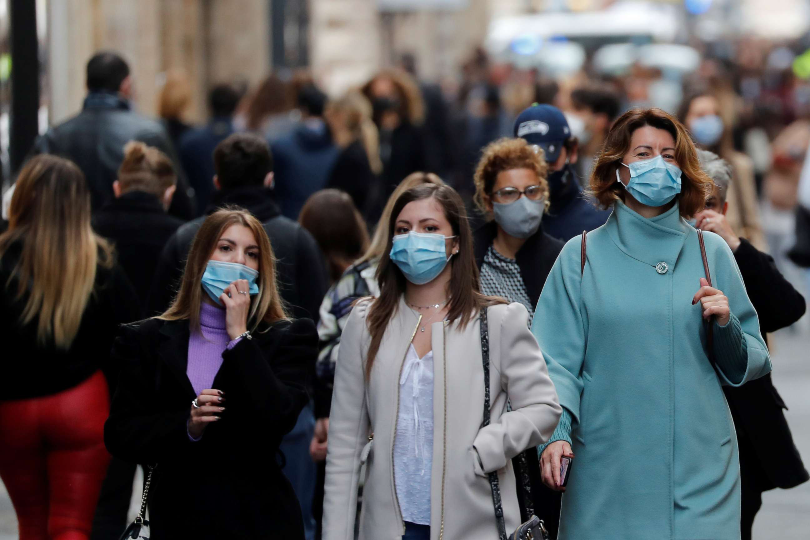 PHOTO: People wearing protective masks walk along the principal shopping street of Via del Corso, as the number of people infected by COVID-19 continues to rise, in Rome, Nov. 14, 2020.