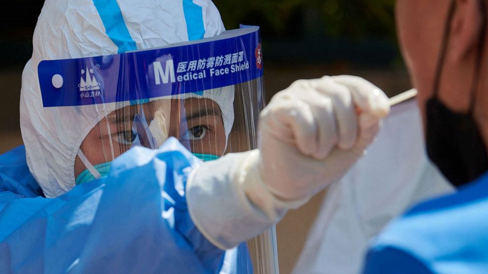 PHOTO: A health worker wearing personal protective equipment conducts a swab test for the COVID-19 coronavirus in Shanghai, April 17, 2022.